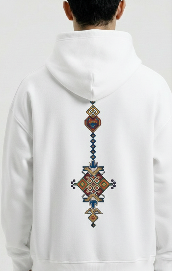 White hoodie with a colorful geometric pattern on the back, worn by a person against a white background.