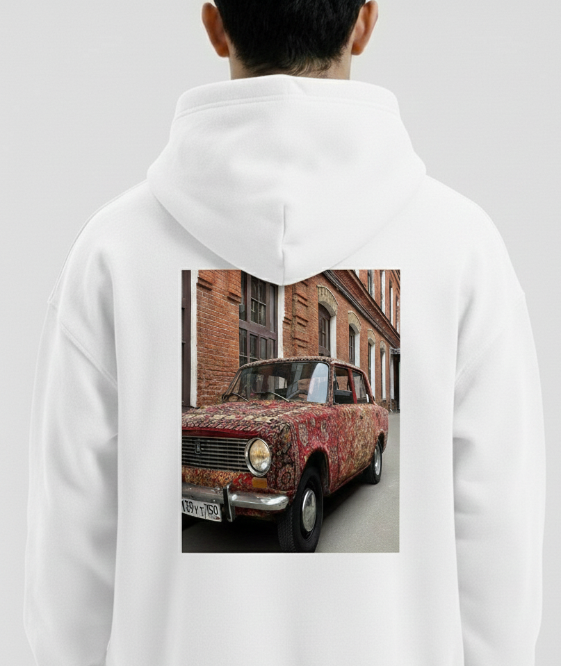 White hoodie with a printed design of a vintage car on the back, displayed on a person against a plain background.