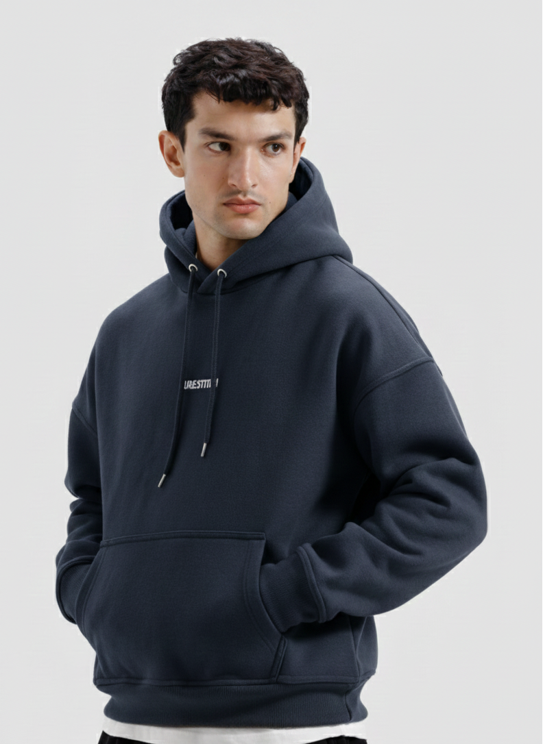 Man wearing a navy blue hoodie with a small logo on a light gray background