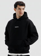Man wearing a black hoodie with a brand logo on a light gray background